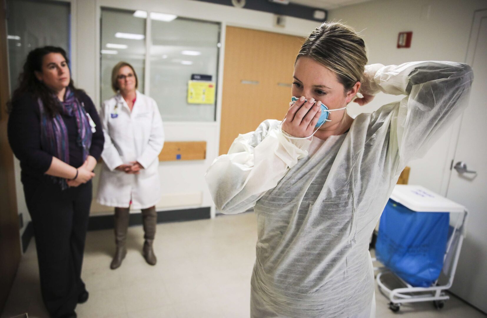 Kaylen Smith demonstrates how to don the protective gear that must be worn when dealing with patients with an infectious disease at Massachusetts General Hospital in Boston. 
The American Hospital Association called on Democrats to spike a provision in the COVID-19 response bill that would require them to shield nurses from exposure to the novel coronavirus.