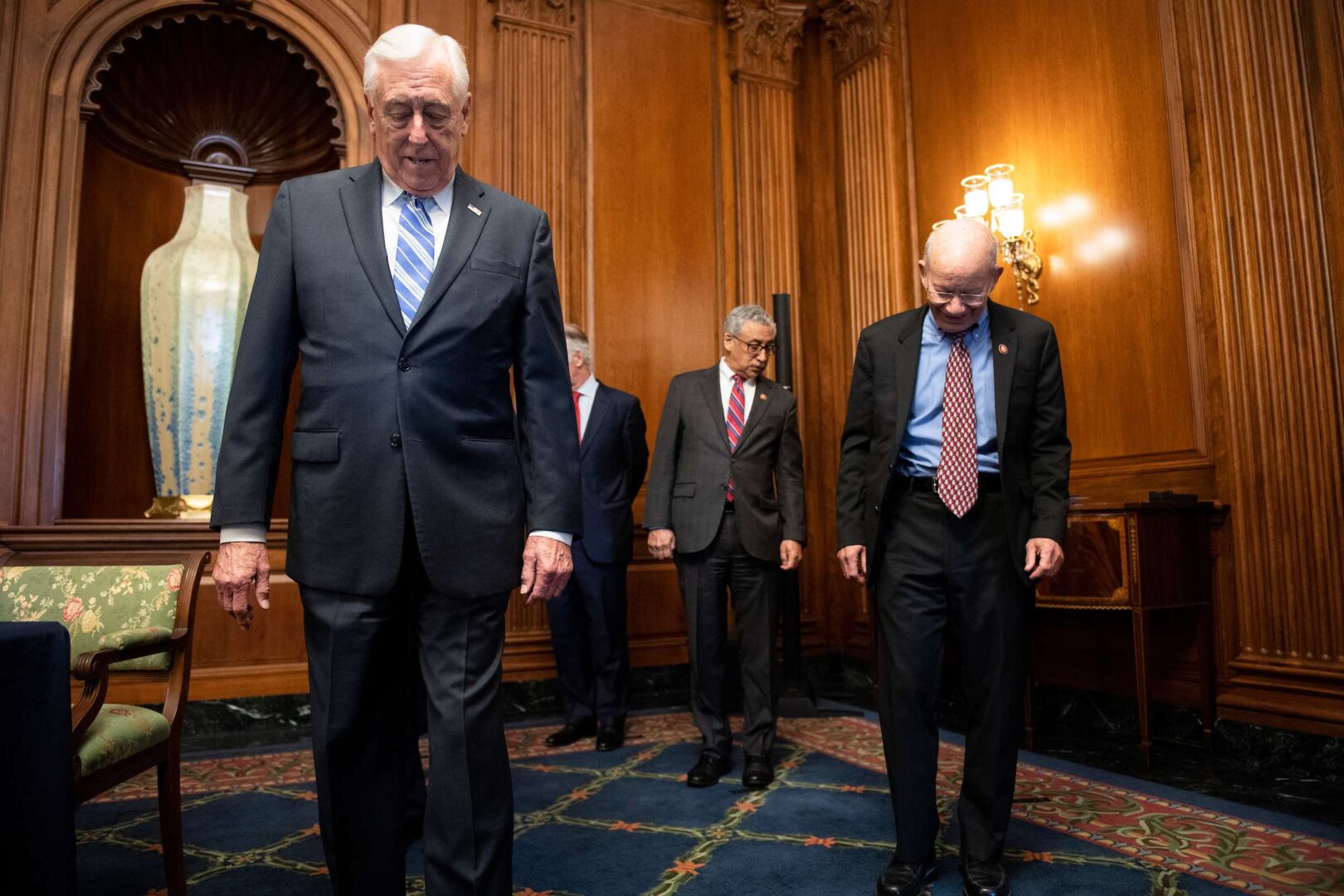 House Majority Leader Steny H. Hoyer, D-Md., left, Rep. Bobby Scott, D-Va., and Rep. Peter DeFazio, D-Ore., look down at their marked spots on the carpet as they followed social distancing measures before an enrollment ceremony for the Coronavirus Aid, Relief, and Economic Security (CARES) Act Friday.