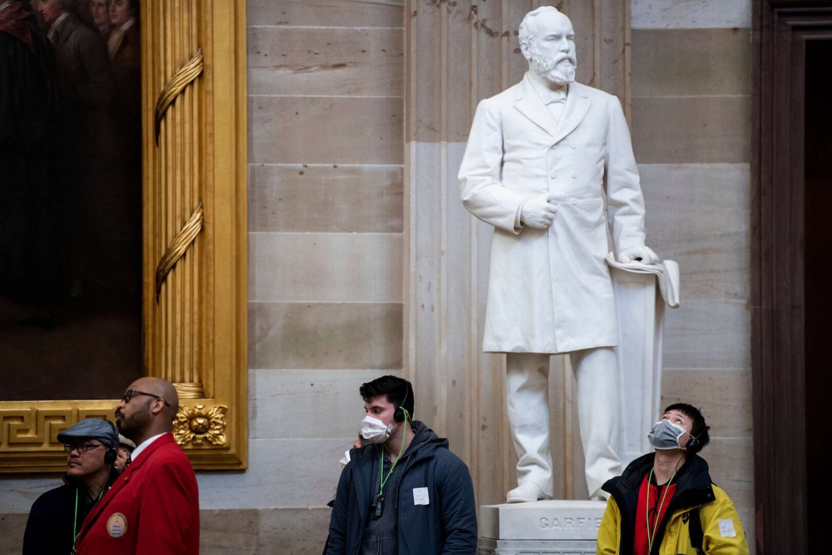 Tourists wearing protective masks tour the U.S. Capitol Rotunda.