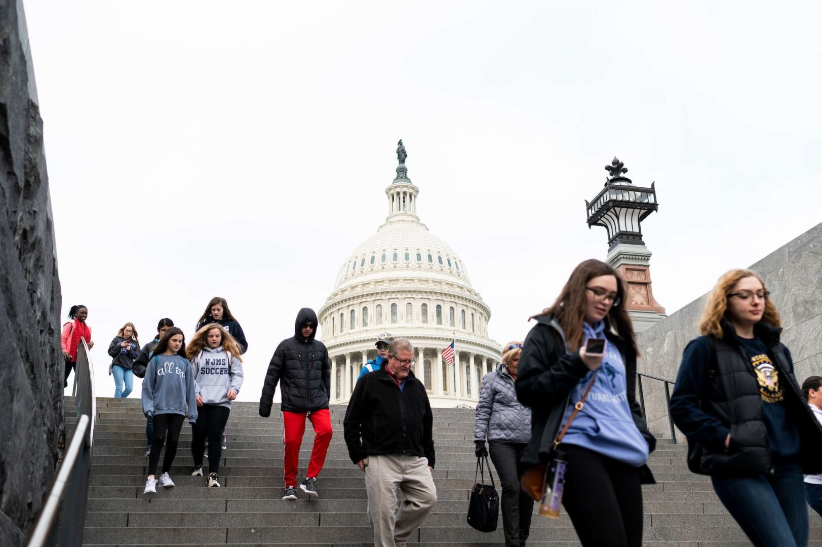 Tourists walk in front of the Capitol down the steps to the Capitol Visitor Center  on Thursday. Tours of the Capitol were suspended Thursday morning due to the coronavirus pandemic.