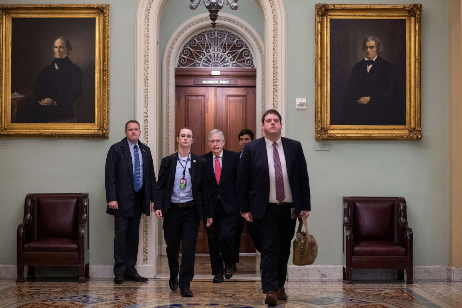 Senate Majority Leader Mitch McConnell, R-Ky., center, arrives to the Capitol before speaking on the Senate floor about a coronavirus stimulus package on Wednesday.