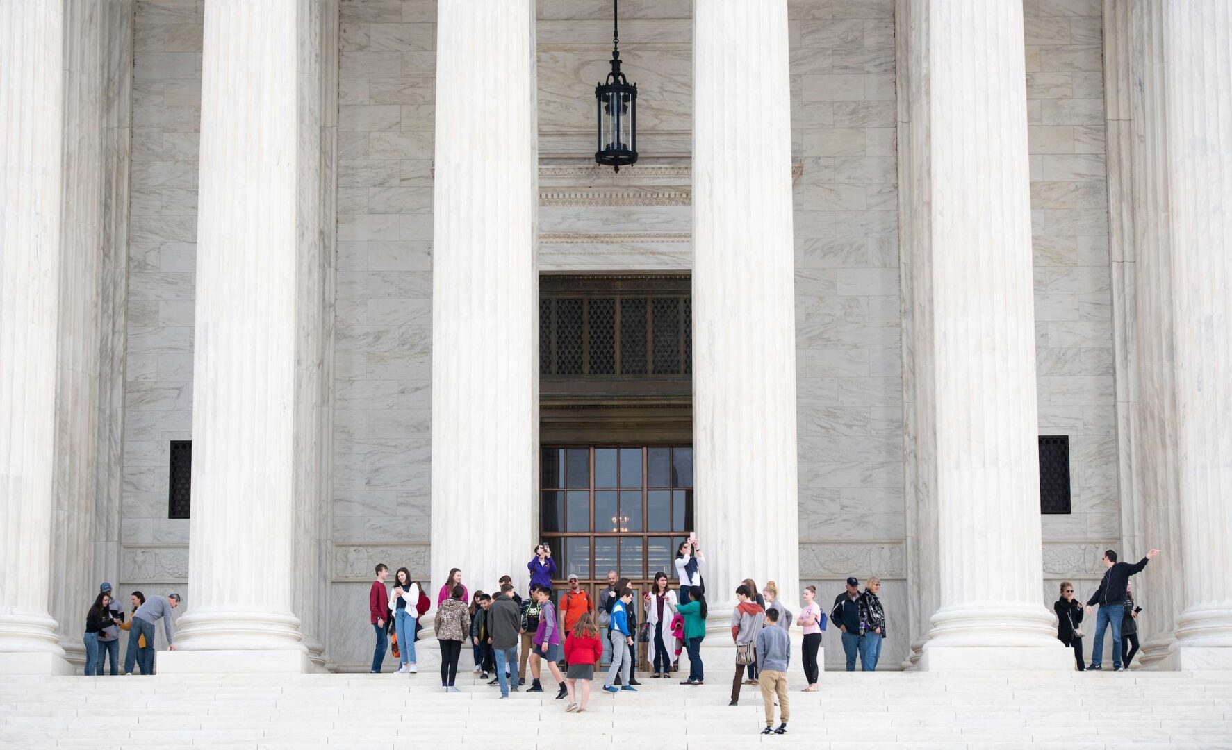 Tourists take photos on the steps of the U.S. Supreme Court on Thursday, March 12, 2020. (Bill Clark/CQ Roll Call)