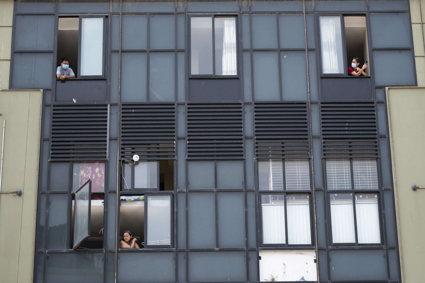 People looking out of their windows while firefighters spray disinfectant in the street as a preventive measure against the COVID-19 coronavirus in Yangon, Myanmar on April 21. (Shwe Paw Mya Tin/NurPhoto via Getty Images)