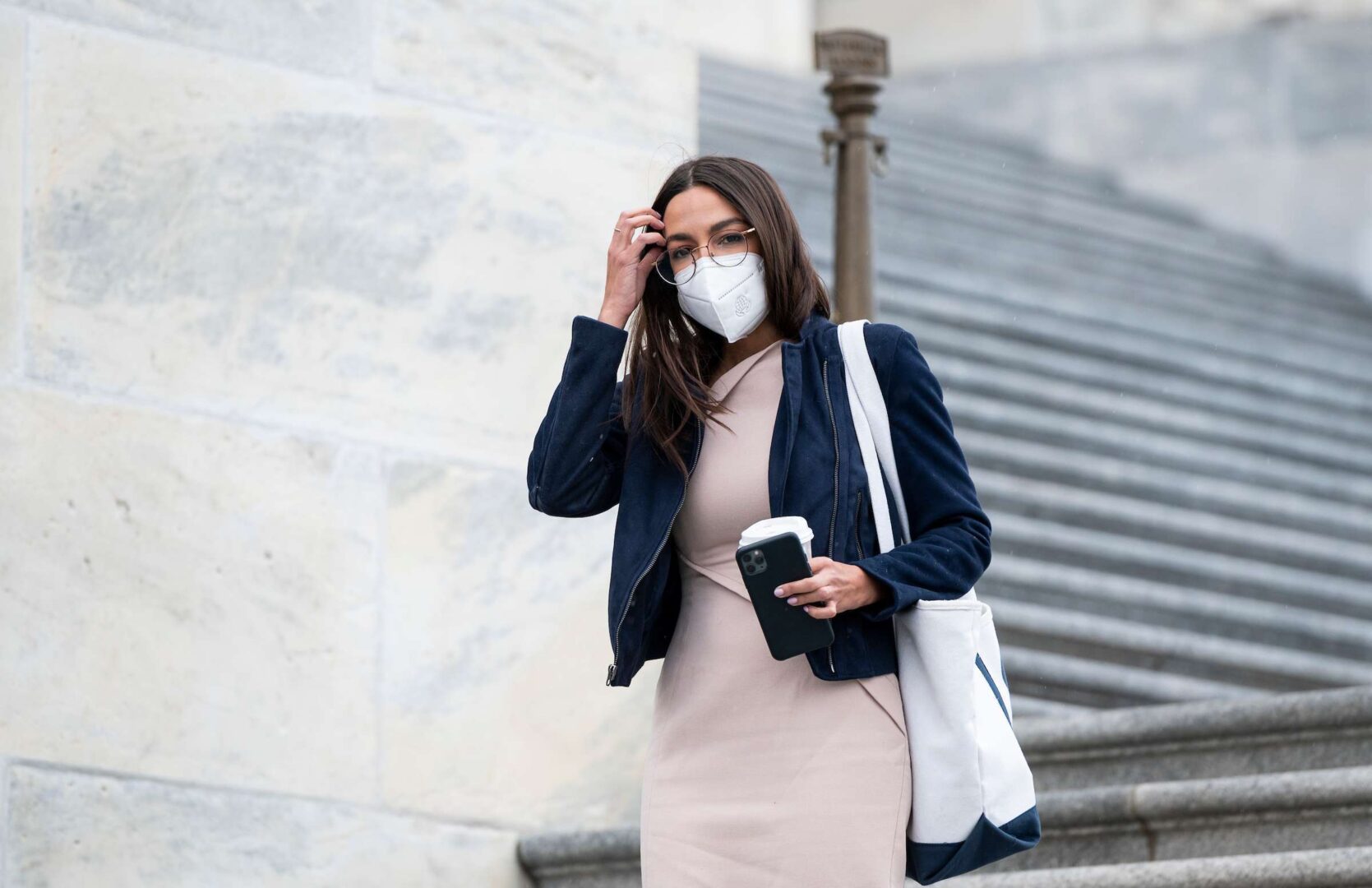 The bill by Rep. Alexandria Ocasio-Cortez, D-N.Y., shown here at the Capitol in April, would require workers get shares at companies that take federal coronavirus aid.