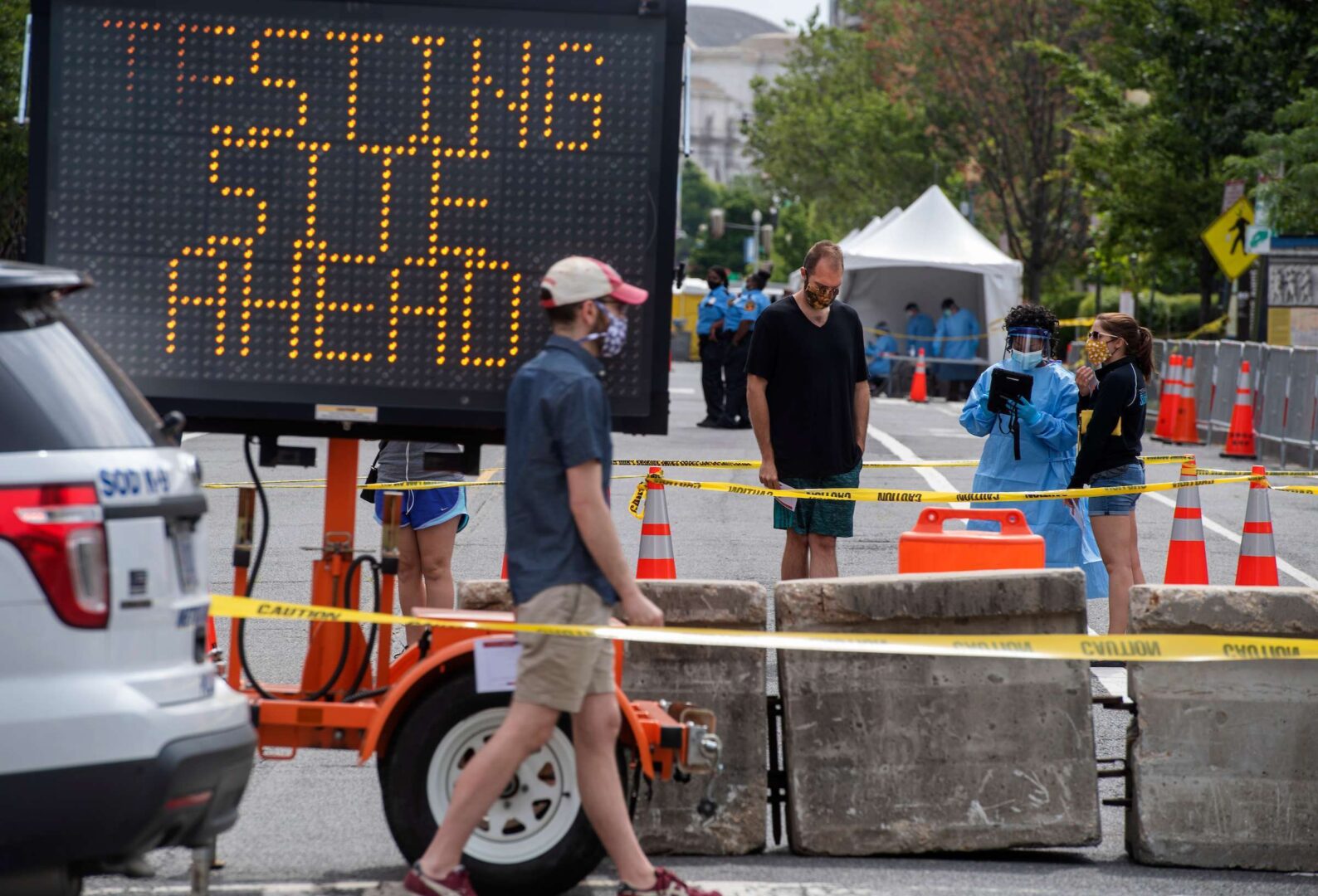 People wait in line outside the National Building Museum for walk-up COVID-19 testing on Monday.