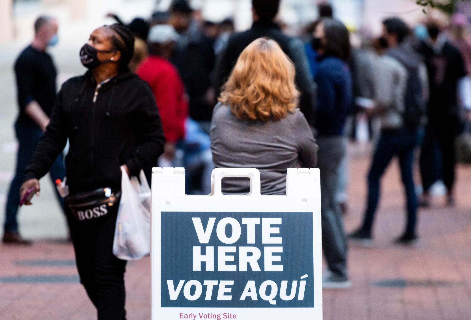 Voters wait Tuesday outside Capital One Arena in Washington on the first day of early voting. 