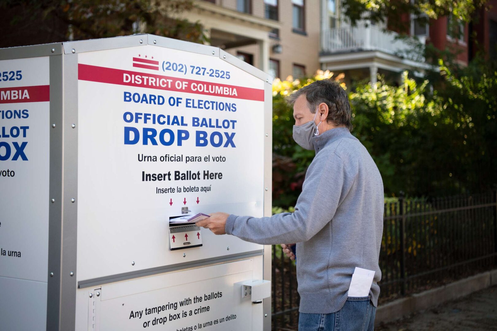 A voter uses the District of Columbia Board of Elections mail-in-ballot drop box in Washington on Oct. 5, 2020. 