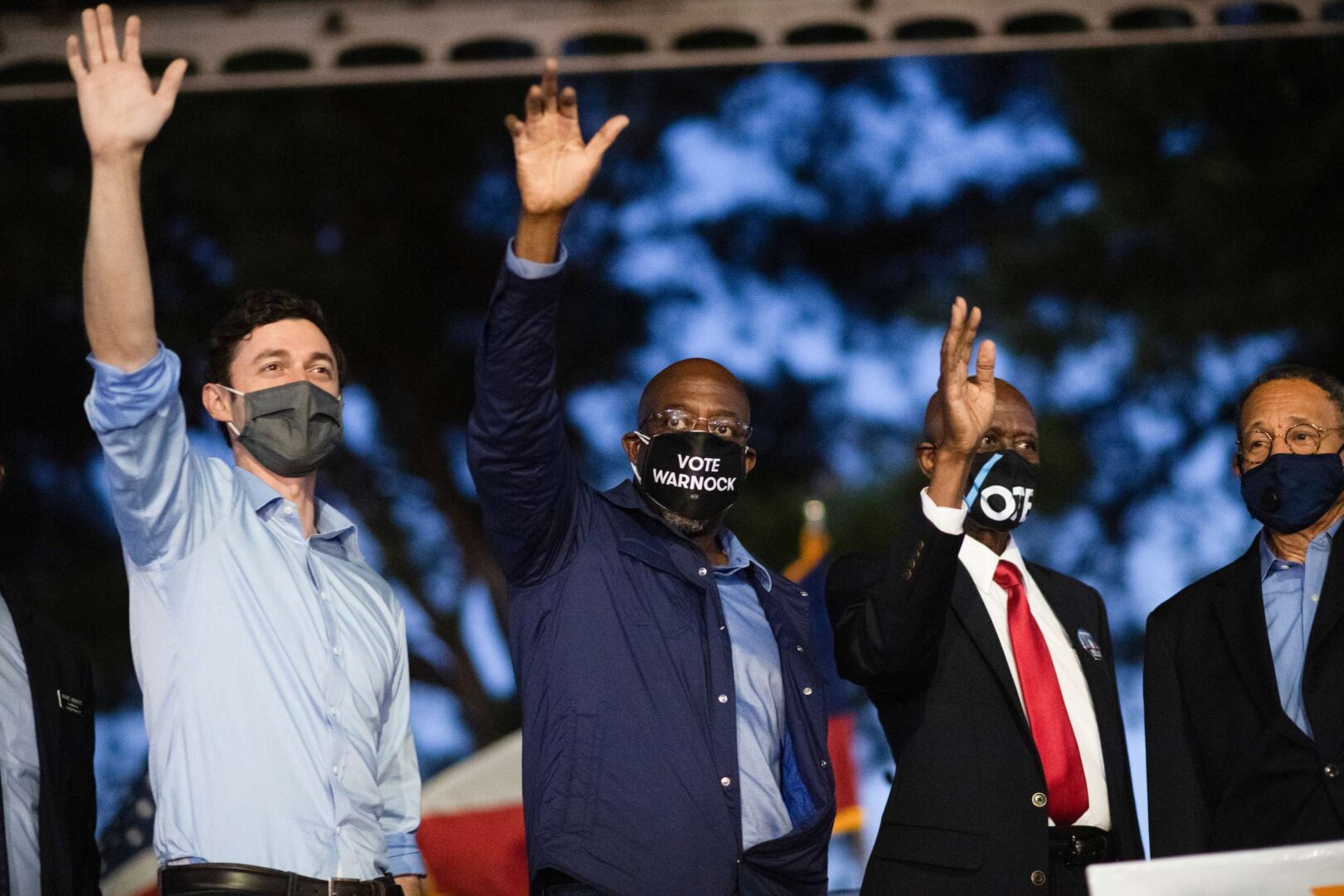 Georgia Democratic candidates for Senate Jon Ossoff, left, and Rev. Raphael Warnock, center, attend a drive-in rally with Muscogee County Democrats at the Civic Center in Columbus, Ga., on Thursday. Rep. Sanford Bishop, D-Ga., appears at right. 