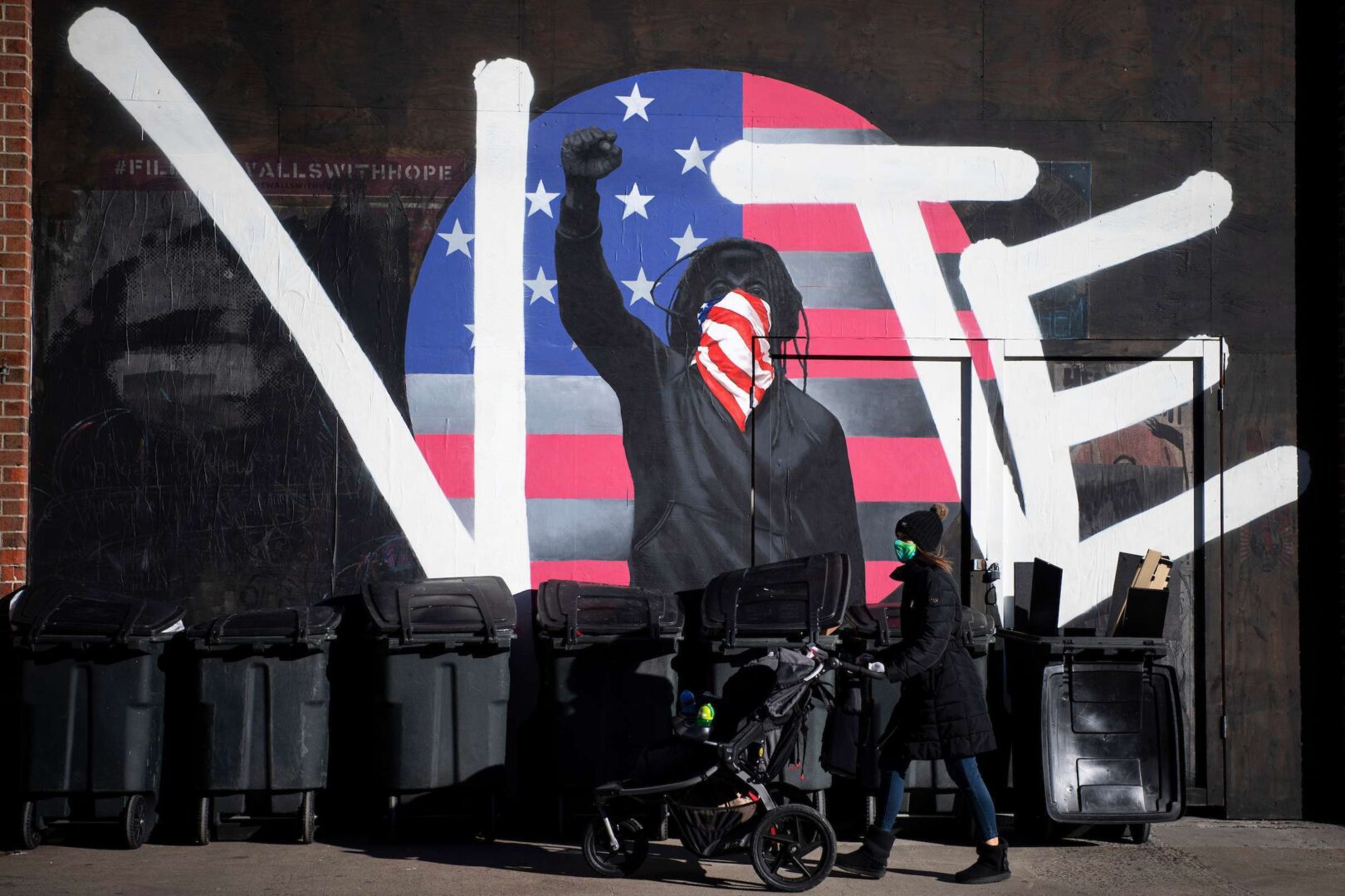 A woman walks by a mural that reads “vote” in Philadelphia on Monday, Nov. 2, 2020. (Caroline Brehman/CQ Roll Call)