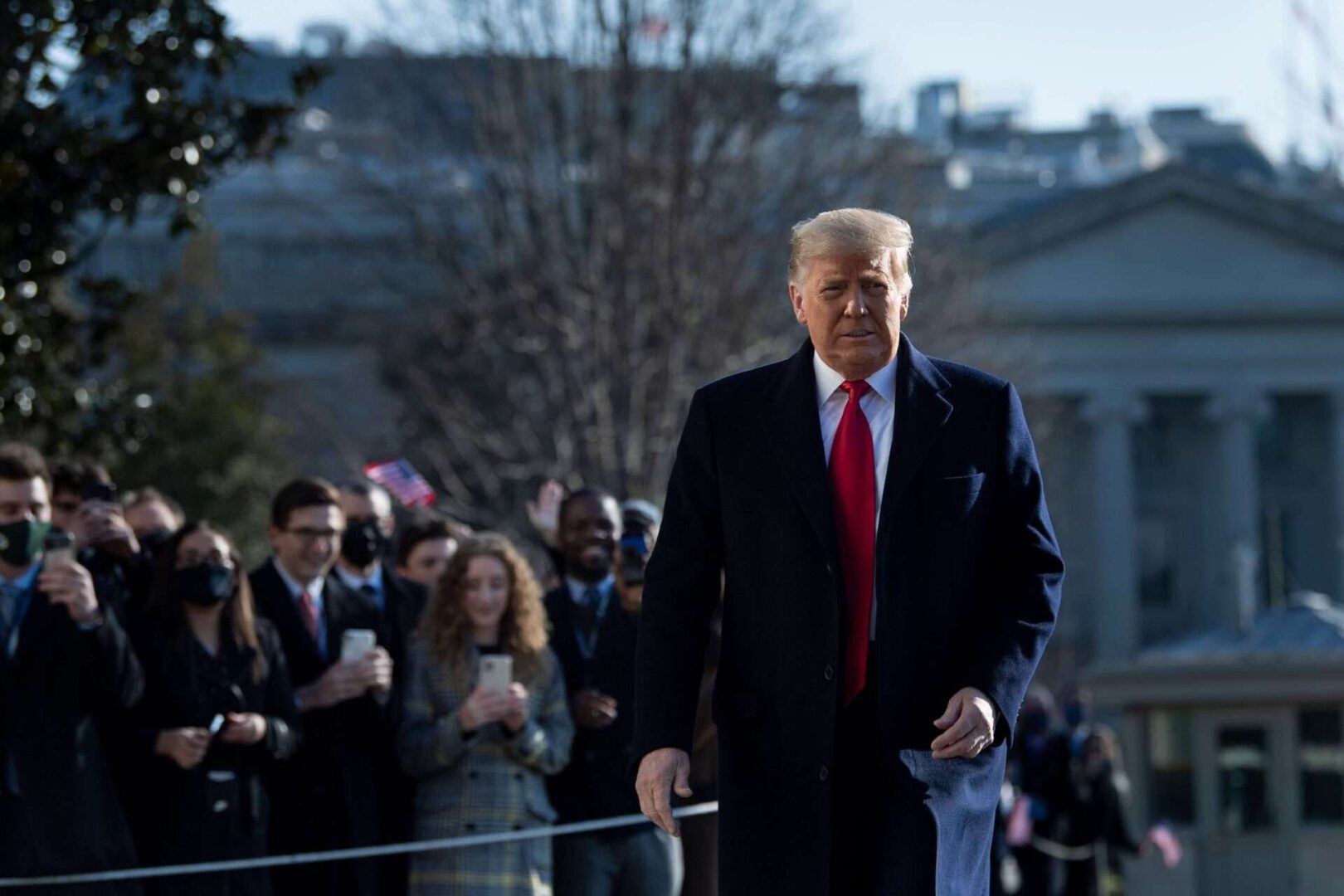 President Donald Trump walks by supporters outside the White House on Tuesday before his departure to Alamo, Texas.