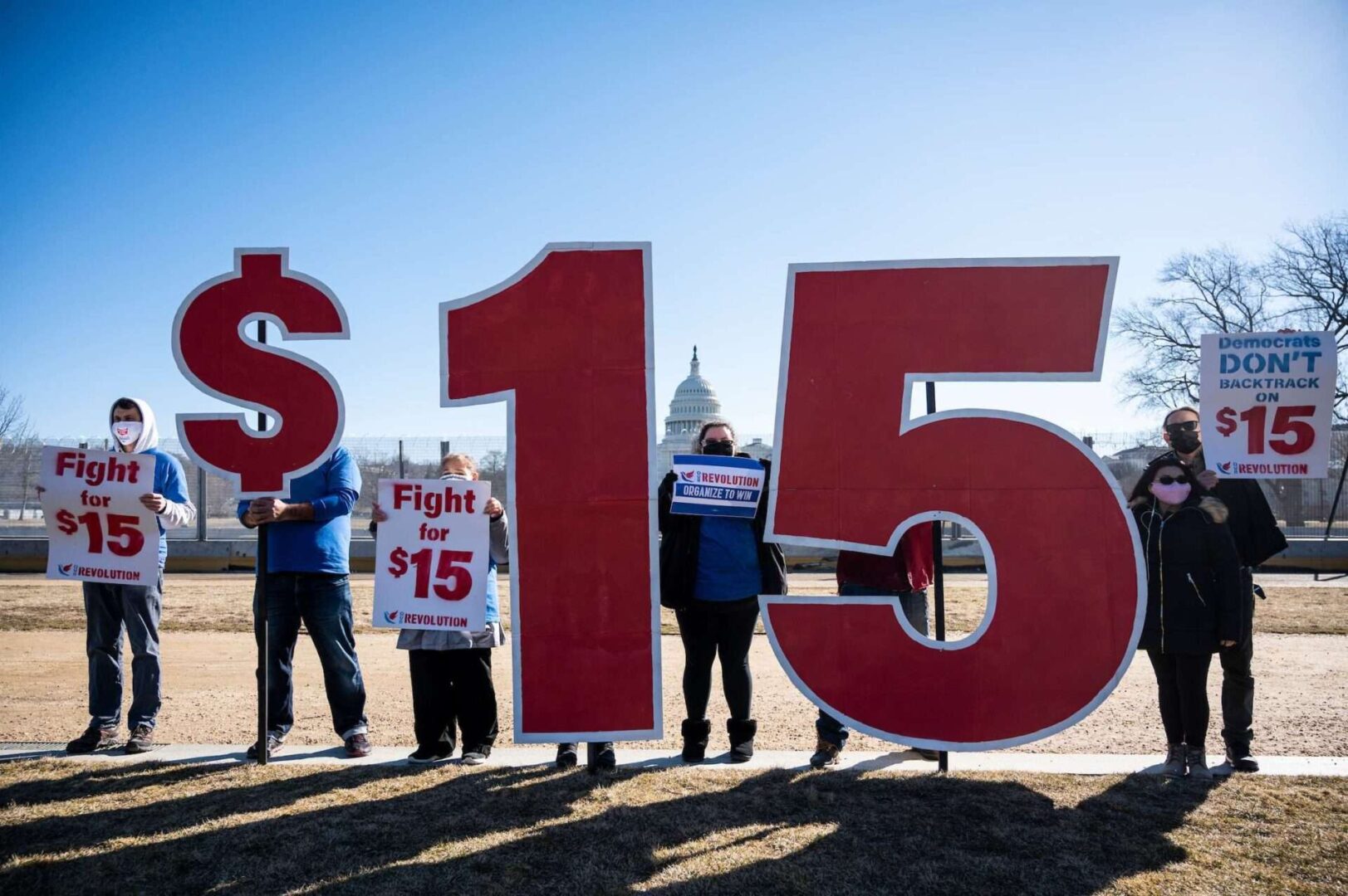 Activists with Our Revolution hold $15 minimum wage signs outside the Capitol complex on Thursday, Feb. 25, 2021, to call on Congress to pass the $15 federal minimum wage hike proposed as part of the COVID-19 relief bill. 