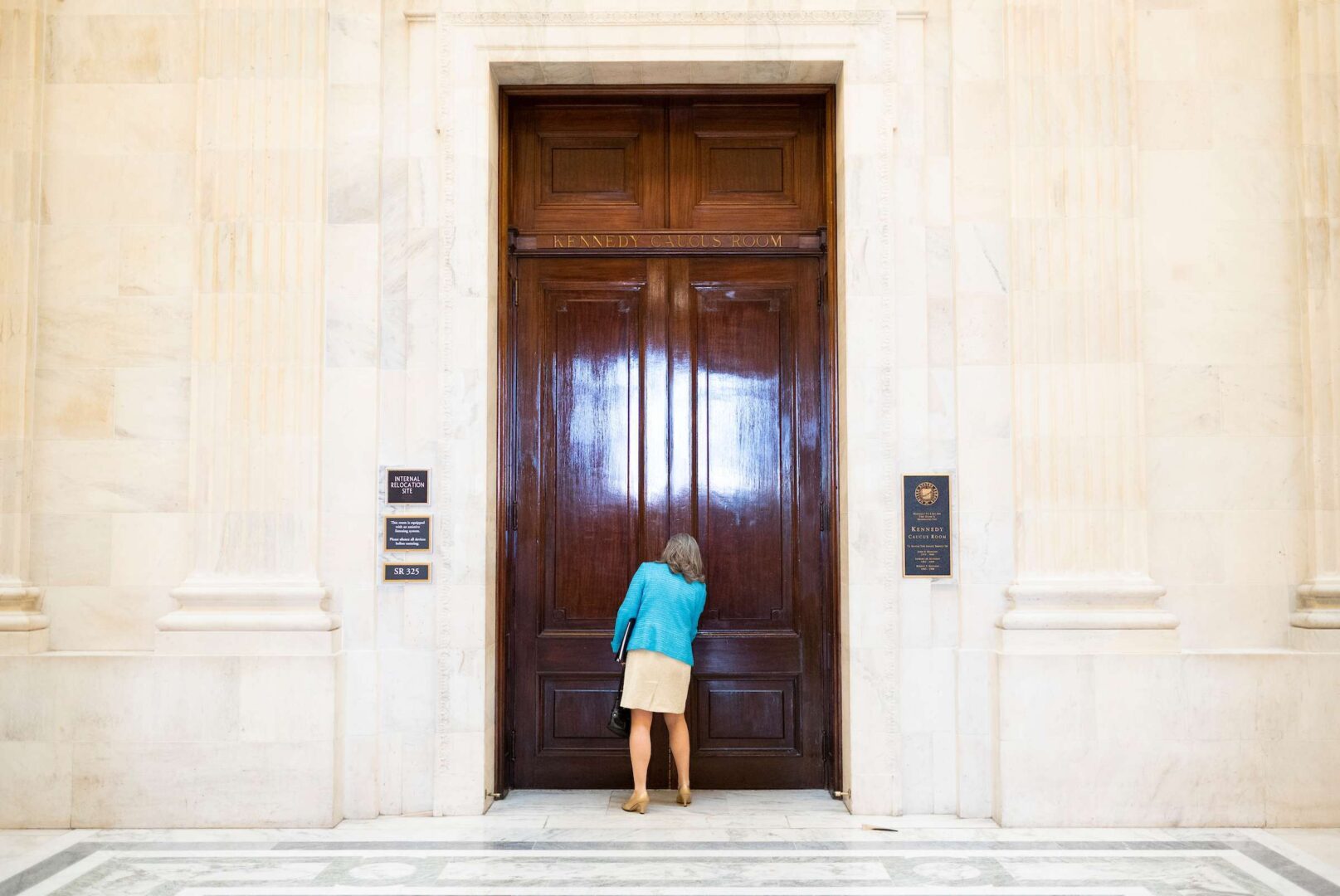 Sen. Joni Ernst, R-Iowa, opens the door to the Kennedy Caucus Room in the Russell Senate Office Building as she arrives for the Senate Republican lunch on Tuesday, March 16, 2021. 