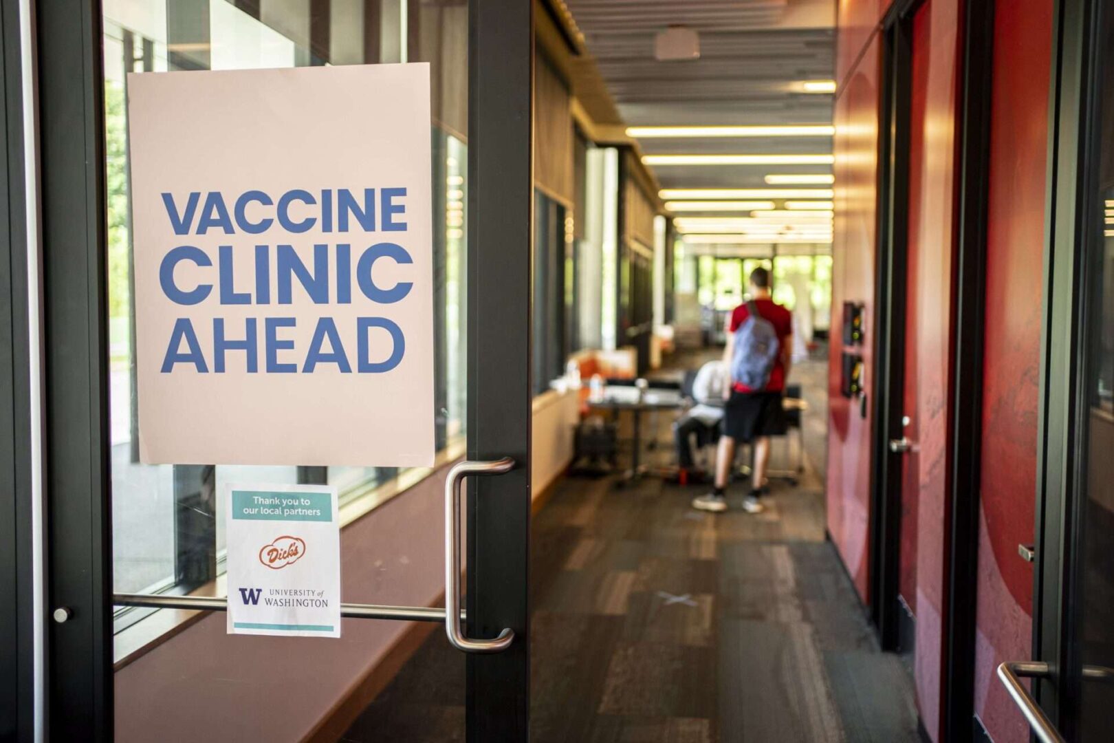 A sign directs patients at a COVID-19 vaccination clinic on the University of Washington campus on May 18 in Seattle. The two-day clinic offered newly vaccinated patients a free hamburger afterward.