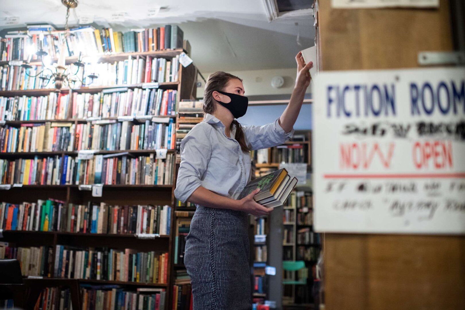 UNITED STATES - JUNE 1: Hélène Golay stocks inventory at Capitol Hill Books on C Street, SE, on the day the store reopened to indoor customers after being closed for several months due to COVID-19, on Tuesday, June1, 2021. (Photo By Tom Williams/CQ Roll Call)