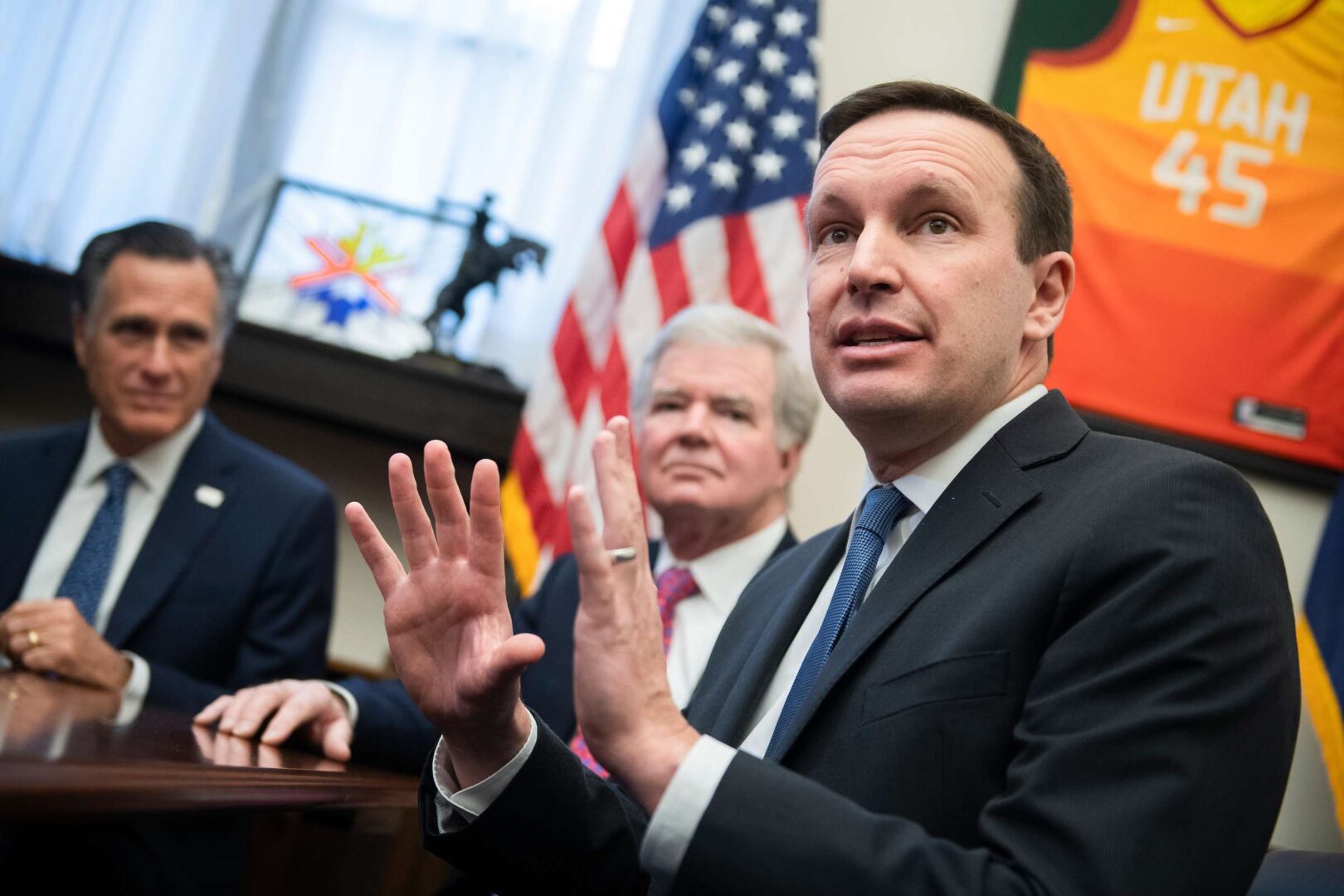 Sens. Chris Murphy, D-Conn., right, Mitt Romney, R-Utah, left, and NCAA president Mark Emmert, conduct a news conference on student athlete compensation on Dec. 17, 2019. 
