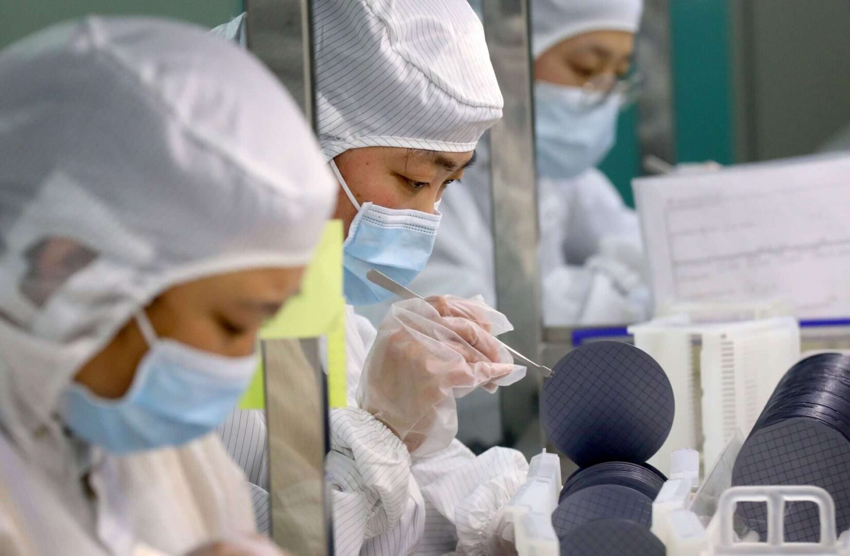 Employees work on the production line of silicon wafer at a workshop of Jiejie Semiconductor Co., Ltd on March 17, 2021 in Nantong, Jiangsu Province of China. 