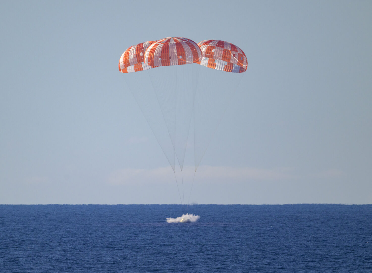 In this handout photo provided by NASA, NASA's Orion spacecraft with Artemis II crewmembers NASA astronauts Reid Wiseman, commander; Victor Glover, pilot; Christina Koch, mission specialist; and Canadian Space Agency astronaut Jeremy Hansen, mission specialist aboard, is seen as it lands in the Pacific Ocean off the coast of California, Friday, April 10, 2026. The 10-day journey took astronauts around the Moon and back to Earth. 