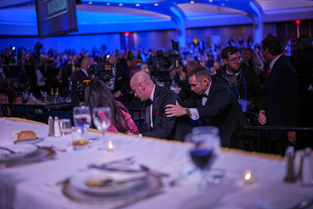Katie Miller and Stephen Miller are escorted out after an incident at the annual White House Correspondents Association Dinner on Saturday in Washington, DC. 