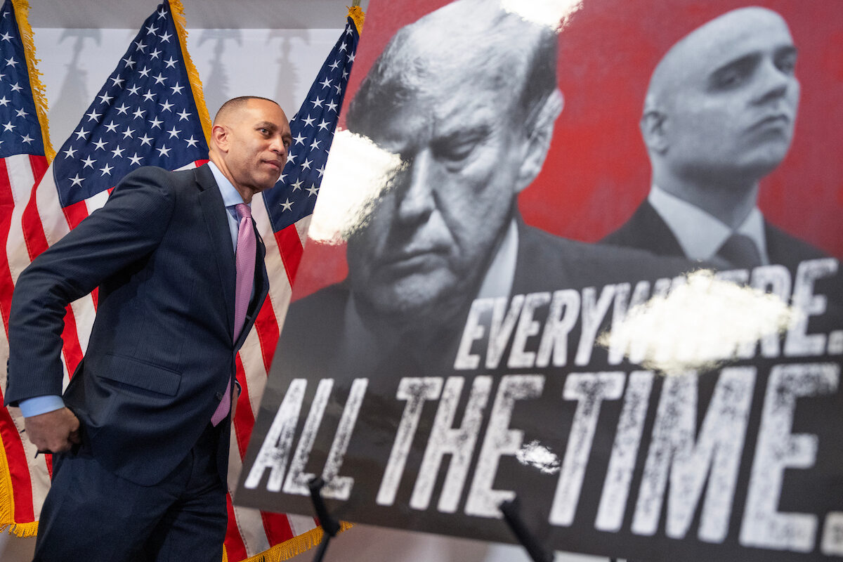 House Minority Leader Hakeem Jeffries attends a news conference Wednesday at the Democratic National Committee in Washington after Virginia voters approved a new congressional map. President Donald Trump and James Blair, who will run Republican midterm operations, appear on the poster.