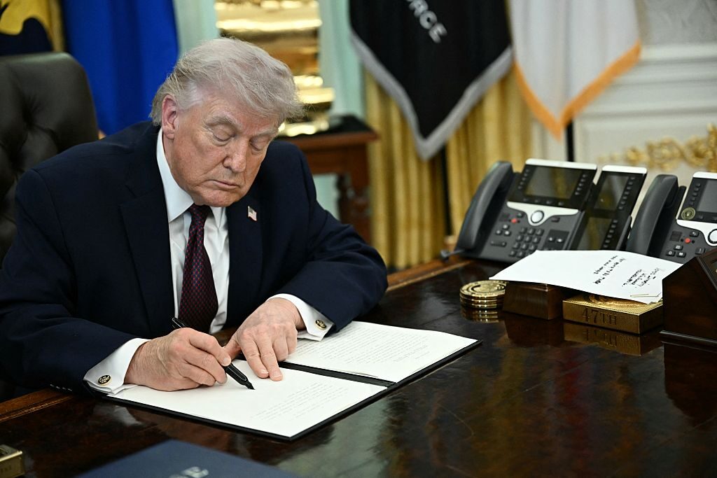 President Donald Trump signs an executive order in the Oval Office in March to put new restrictions on mail-in voting. 