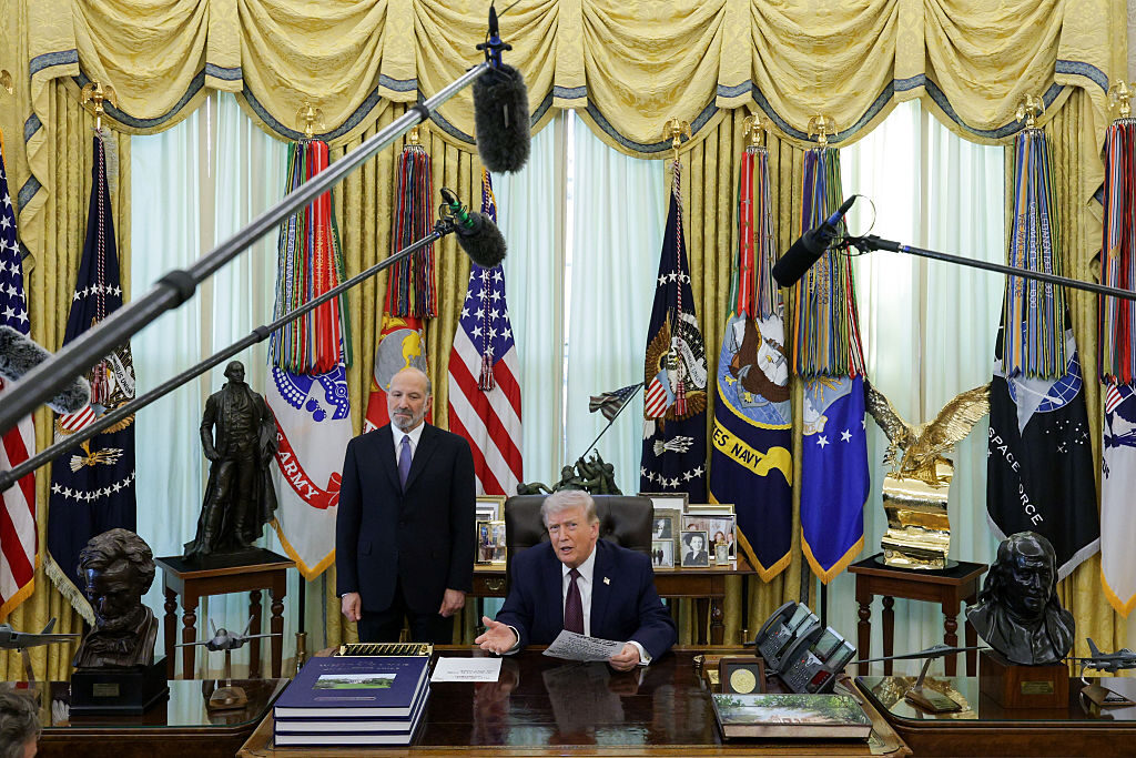 President Donald Trump speaks after signing an executive order in March to limit mail-in voting as U.S. Secretary of Commerce Howard Lutnick looks on in the Oval Office.