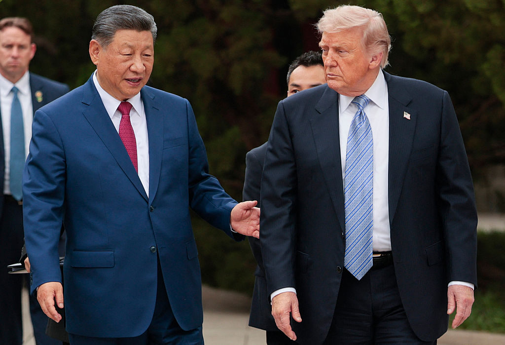 US President Donald Trump walks with China's President Xi Jinping as the US leader departs following a visit to Zhongnanhai Garden in Beijing on May 15. 