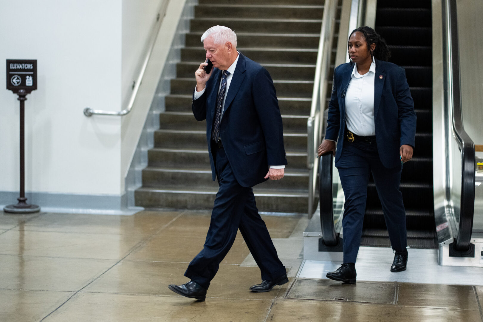 Sen. Lindsey Graham, R-S.C., walks through the Senate subway area in the Capitol with a security detail on June 2.