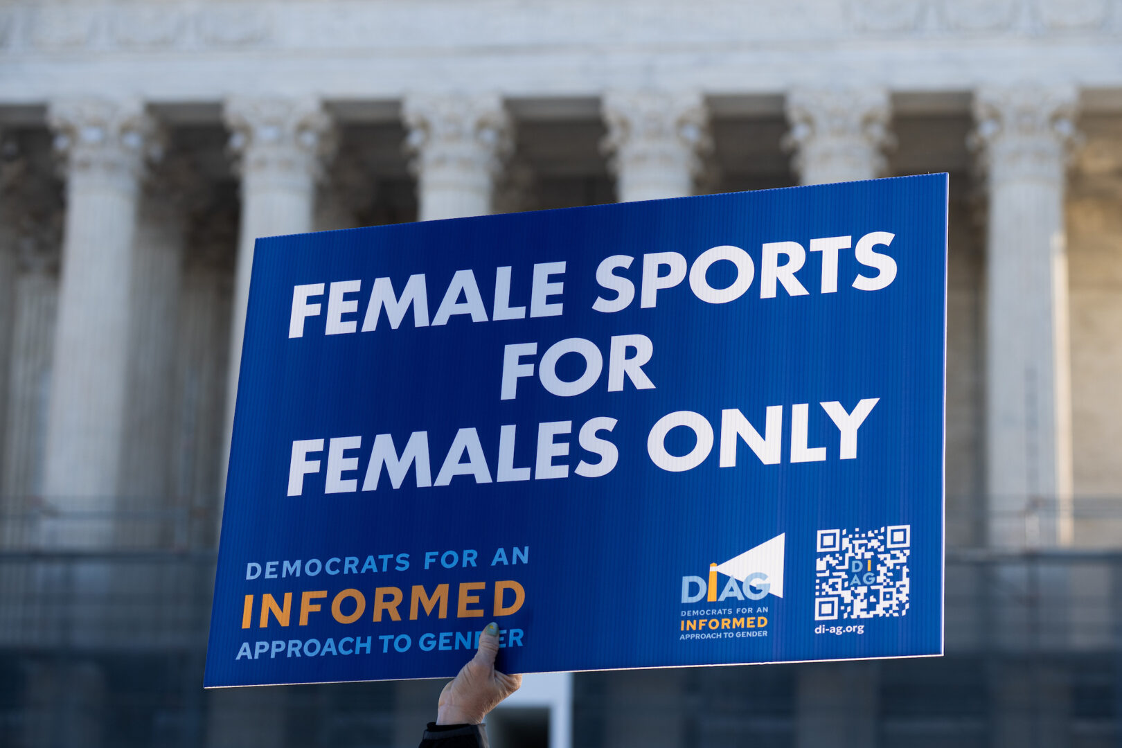 Activists rally outside the Supreme Court in January as the court hears arguments on transgender athlete bans.