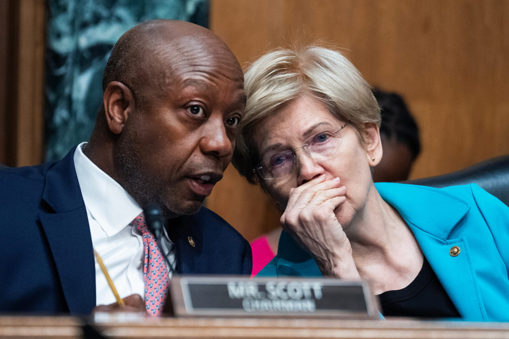 Chairman Tim Scott, R-S.C., and ranking member Elizabeth Warren, D-Mass., confer during a Senate Banking Committee hearing in the Dirksen Senate Office Building on April 21.