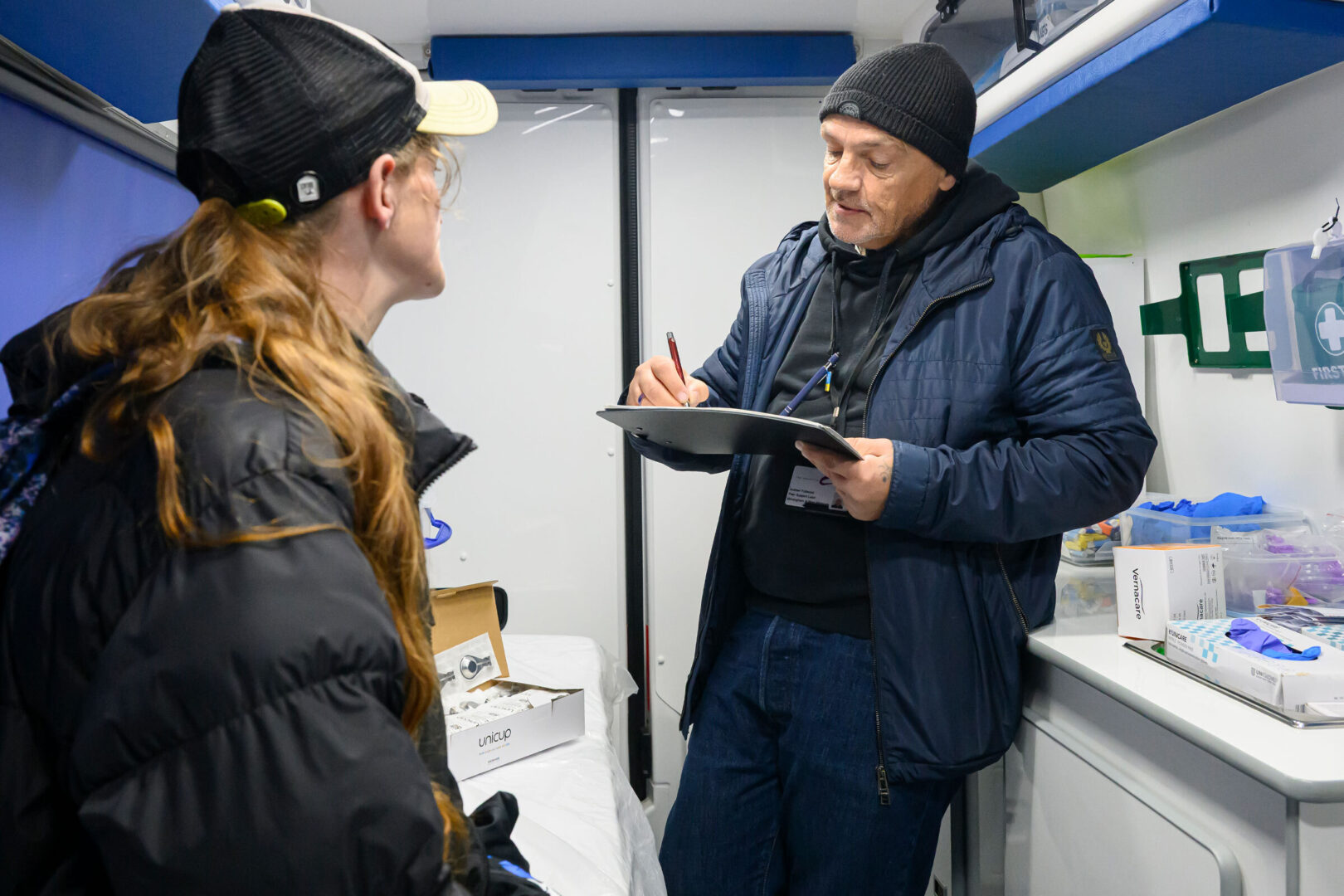 Andrew Fullwood, peer support lead for the Hepatitis C Trust in Birmingham, England, talks with a patient in a van equipped with hepatitis C testing and harm reduction supplies.