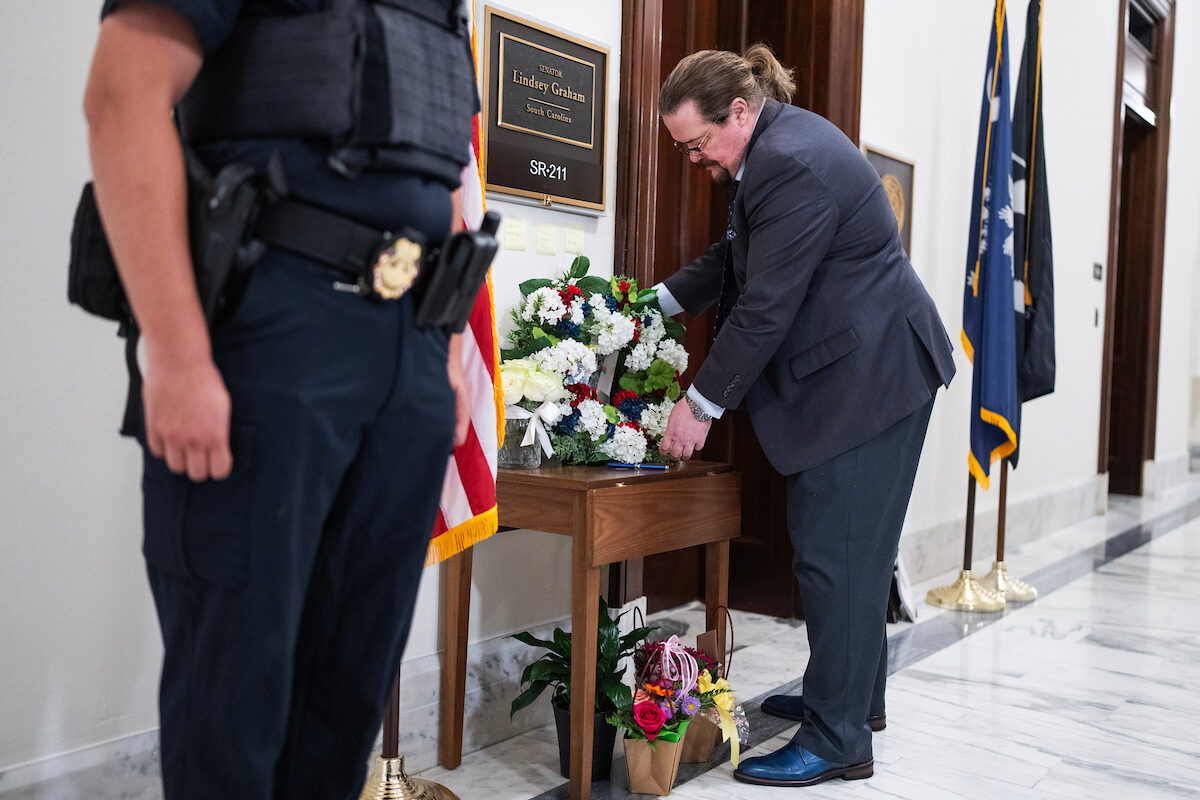 A representative from the  Kurdistan Communities Assembly lays flowers outside the office of the late Sen. Lindsey Graham, R-S.C., on July 13. Graham leaves a legacy as a foreign policy hawk and involved legislator. 
