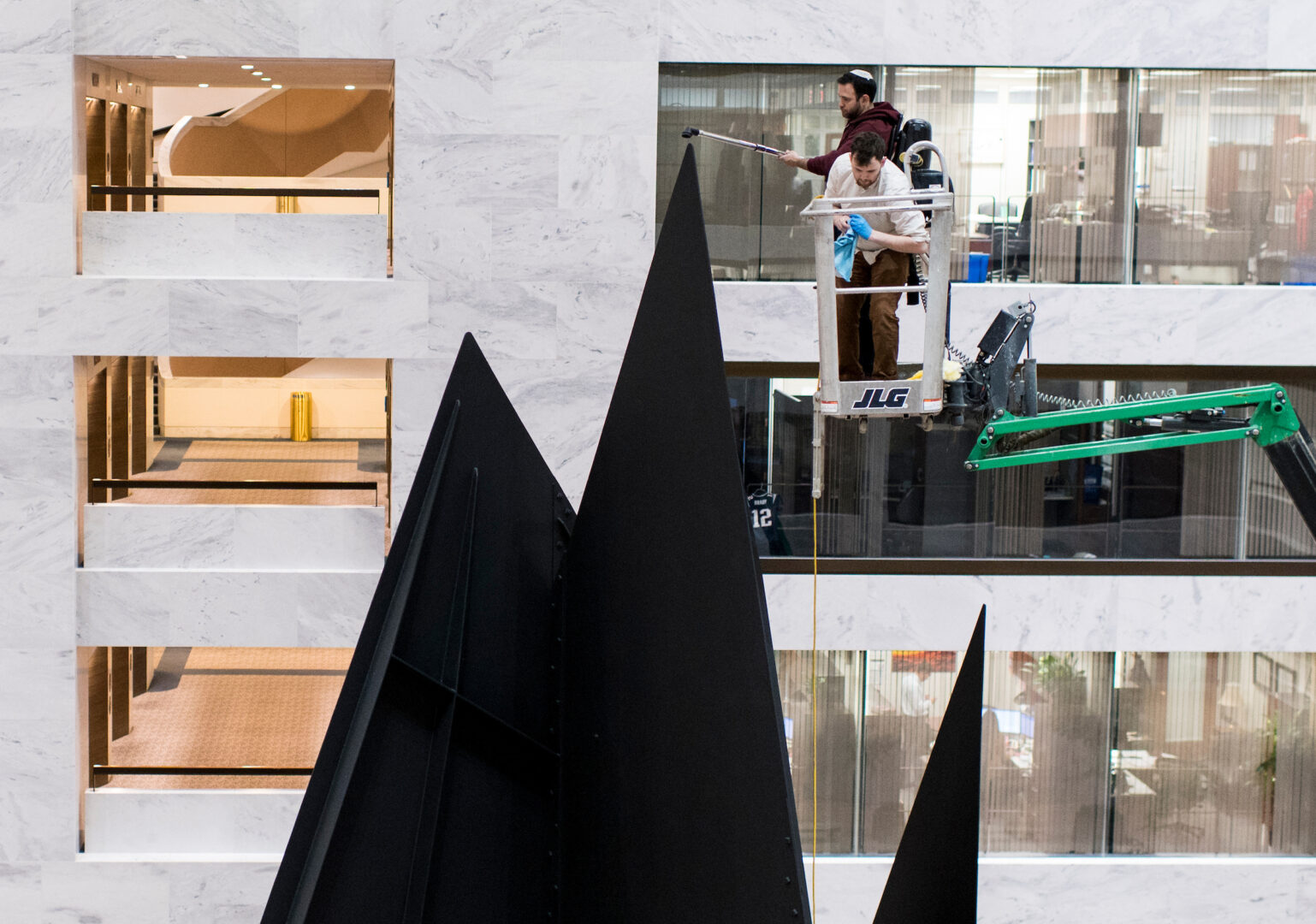 A work crew vacuums the peak of Alexander Calder’s “Mountains and Clouds” installation in the atrium of the Hart Senate Office Building in 2020. The mobile portion of the sculpture, which has been gone for years, is expected to be reinstalled in August.