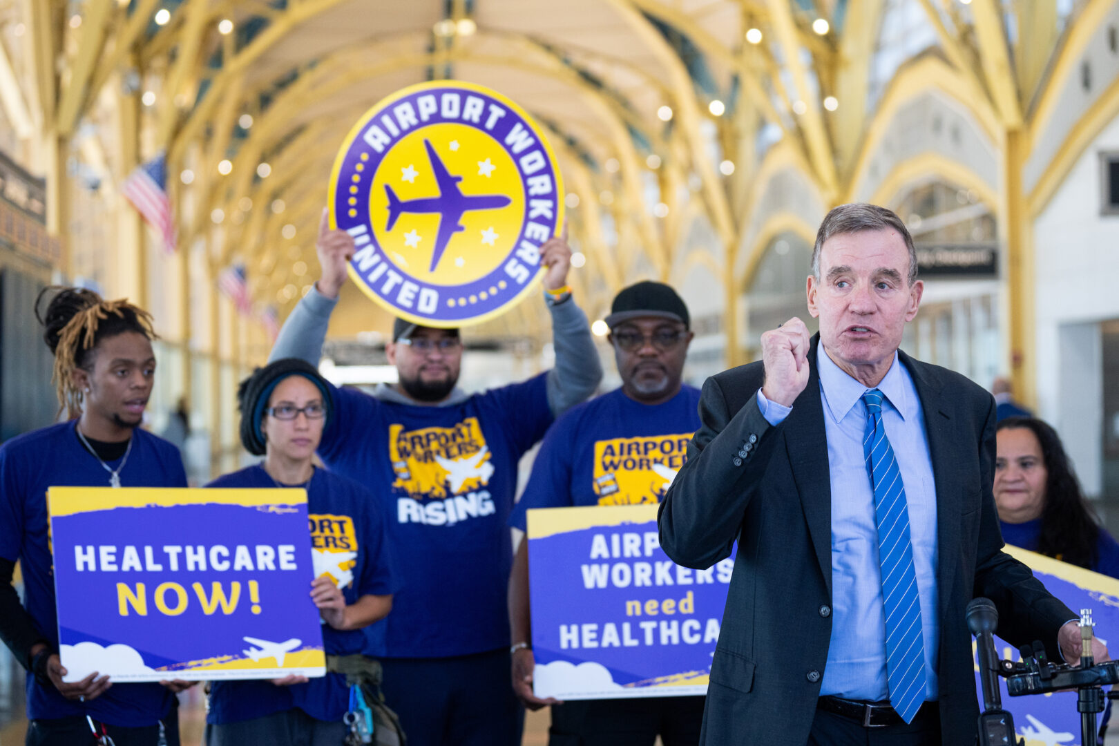 Sen. Mark Warner, D-Va., speaks about affordable health care for airport service workers at Ronald Reagan Washington National Airport in Arlington, Va., on Wednesday.
(Bill Clark/CQ Roll Call)

